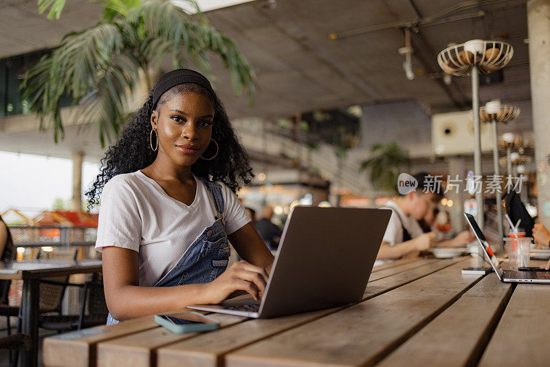 年轻的黑人女学生在网吧使用电脑。