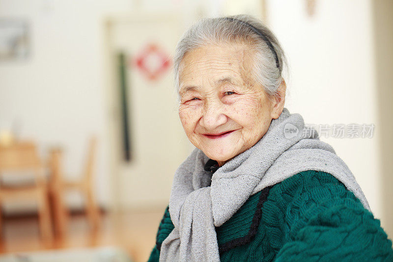 肖像年长亚洲妇女看着相机微笑