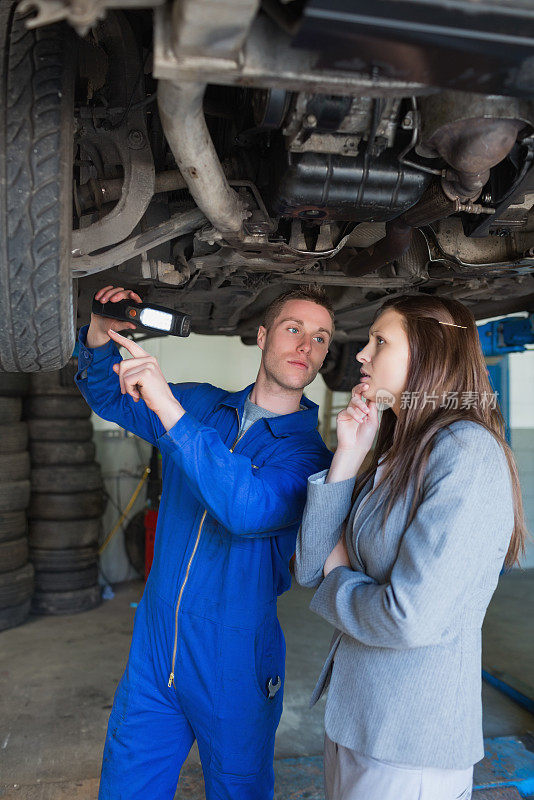 汽车修理工和女人检查汽车轮胎