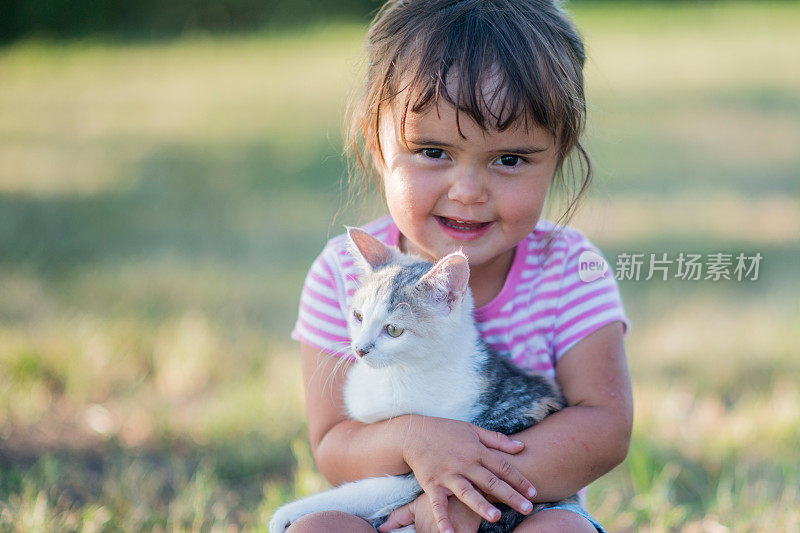 小女孩抱着一只小猫