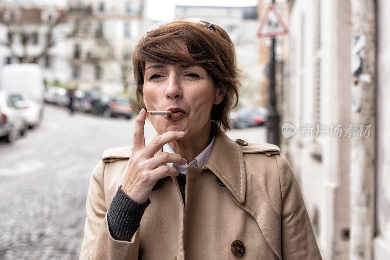 优雅的巴黎女子在街头吸烟
