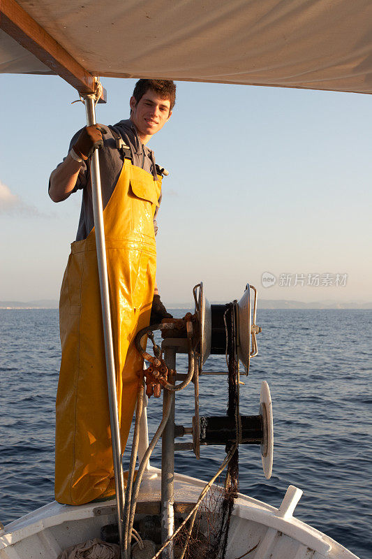 年轻的渔夫等着拿渔网。