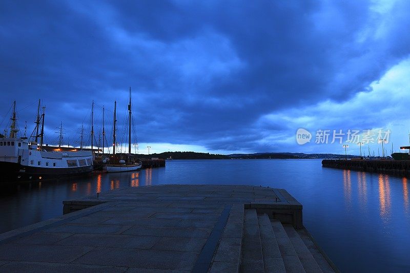 奥斯陆码头港口船舶全景，戏剧性的云夜，挪威，斯堪的纳维亚