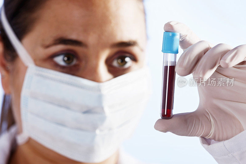 年轻的女科学家专注地检查着一小瓶血液