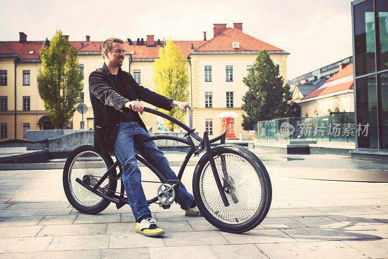 微笑的中年男子在定制的自行车上