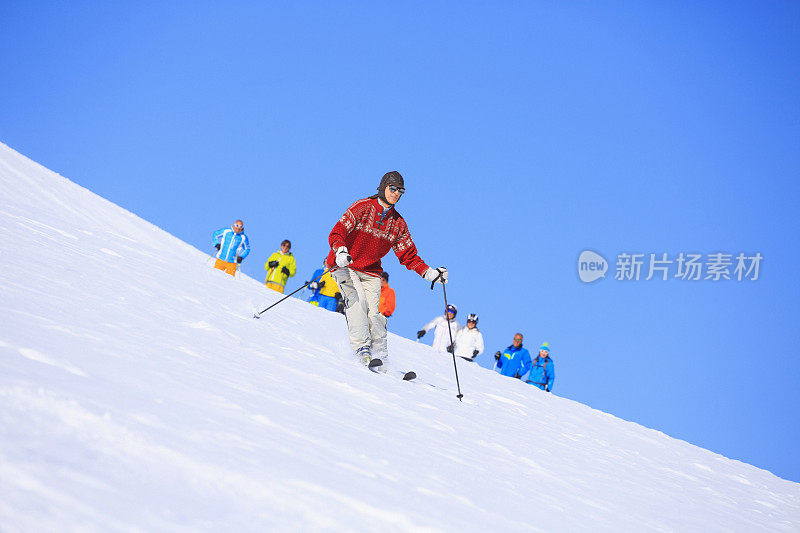 穿着复古滑雪服的男人在阳光明媚的滑雪场滑雪