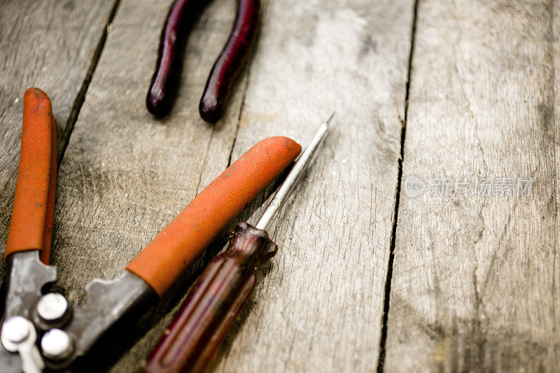 木桌上的施工工具。钳、螺丝刀。