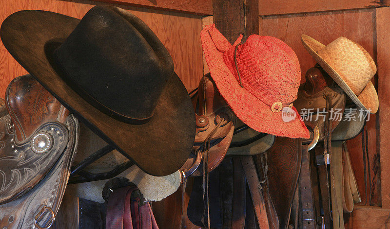 三个帽子和马鞍在牛仔马具室