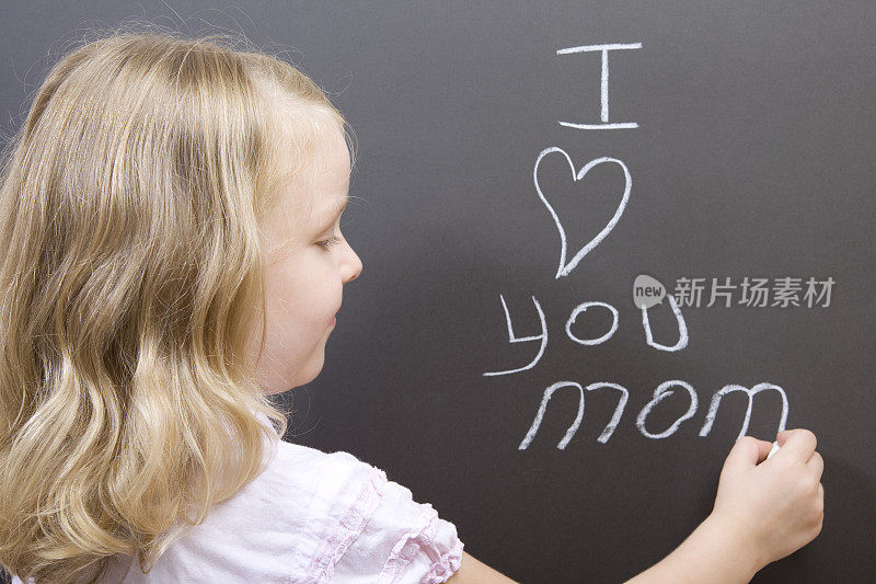 小女孩在黑板上写她对妈妈的爱