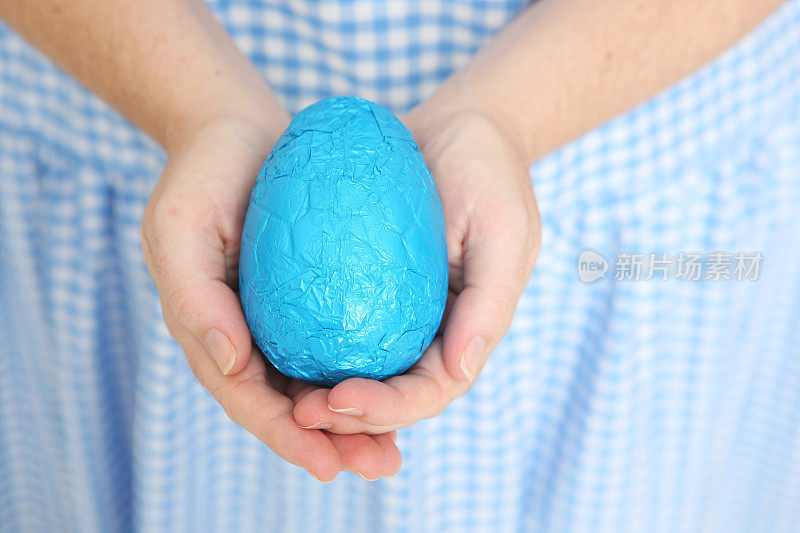 手里拿着蓝色复活节彩蛋