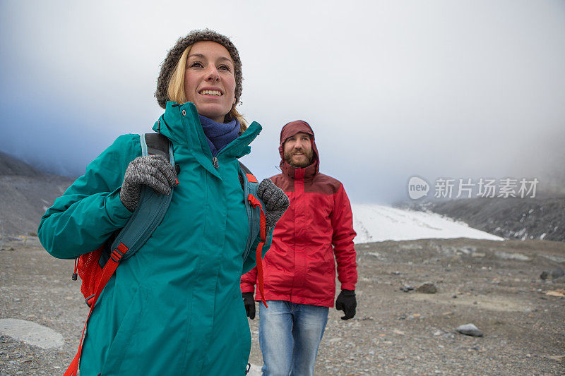年轻愉快的夫妇从冰川徒步下山