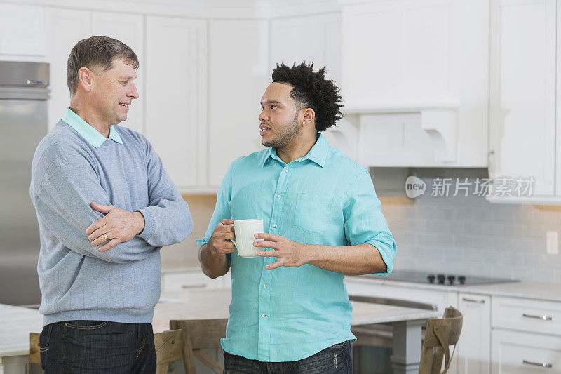 一位长者在厨房和一位年轻的非裔美国人聊天