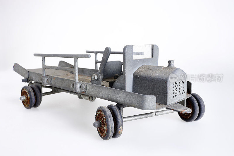 在灰色背景上用金属片制成的老式玩具车