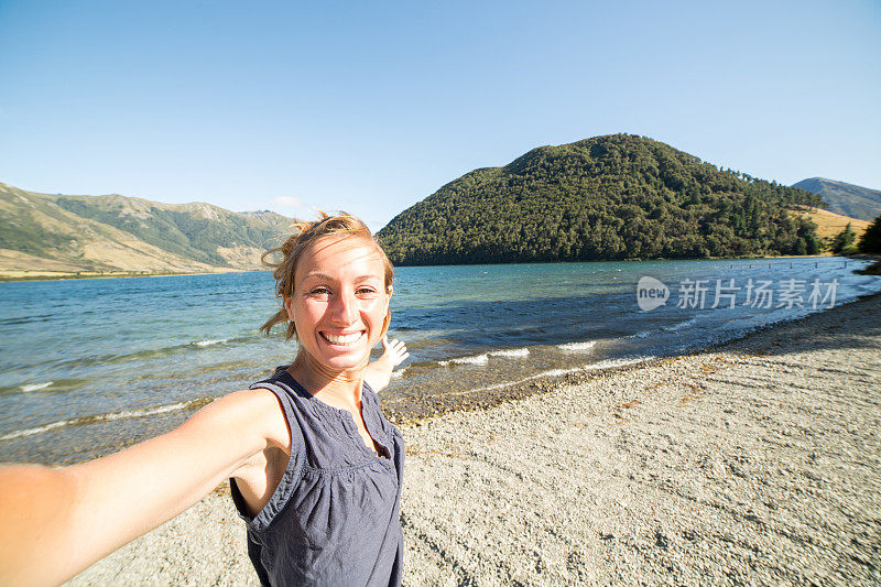 年轻女子在湖边度假的自画像