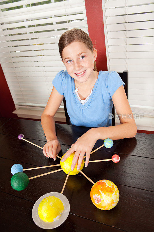年轻的女孩正在构建一个太阳系模型