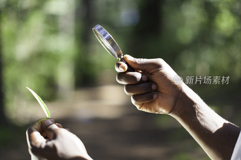 一个非洲人在用放大镜看东西