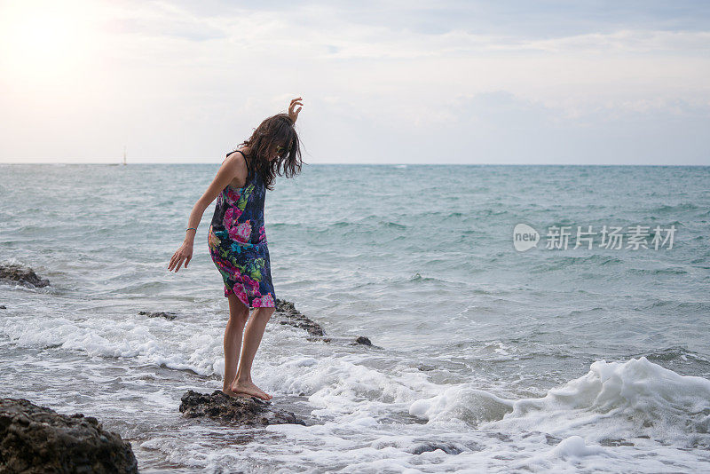 一个年轻女子在海滩上散步