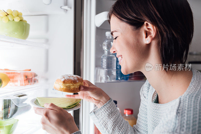 从冰箱里拿糕点的女人