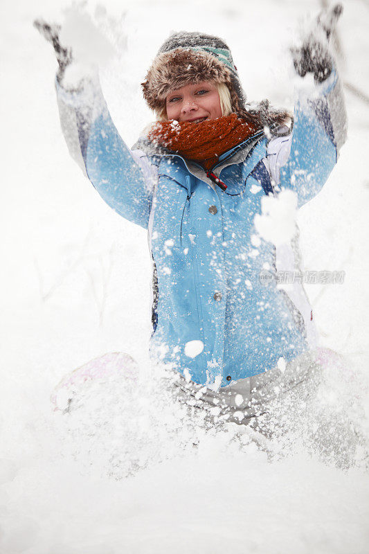 年轻女子在雪中嬉戏