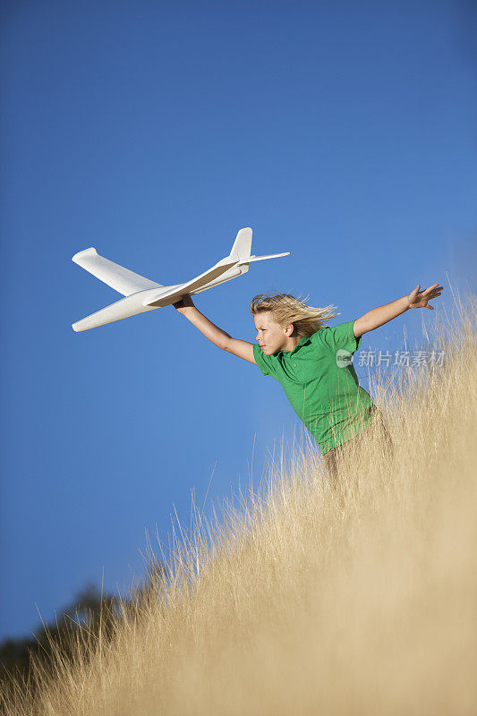 小男孩在野外玩玩具滑翔机飞机