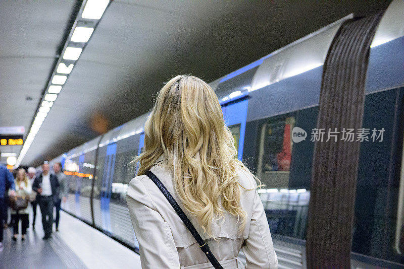 金发瑞典女子进入通勤地铁列车