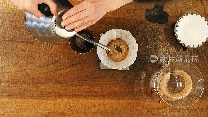 咖啡师用过滤器将水倒在咖啡粉上