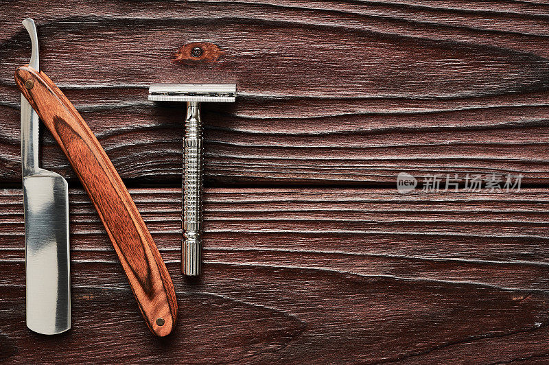 木制背景上的老式理发店剃刀工具