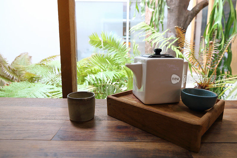 方形茶壶和茶杯放在木托盘上