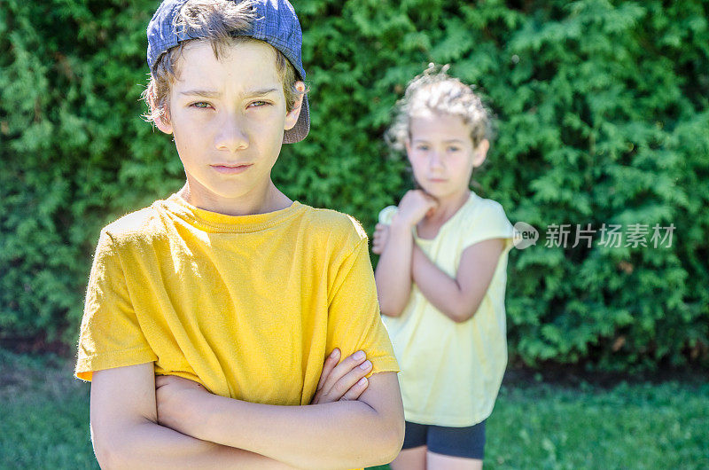 夏日里，一个小男孩站在妹妹面前保护她