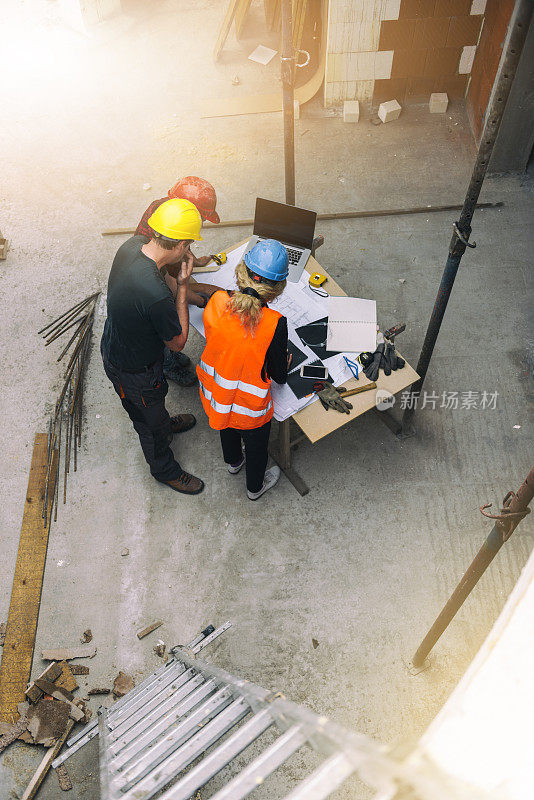 女建筑师和建筑工地的两名建筑工人