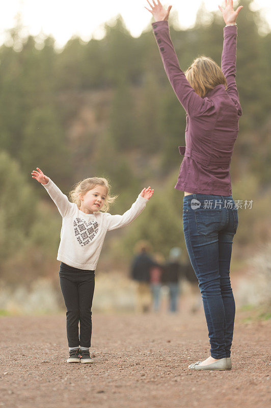 充满活力的妈妈和她的小女儿在大自然中玩耍