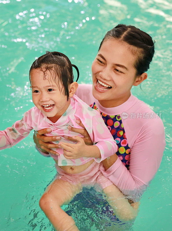肖像快乐的小女孩在游泳池。