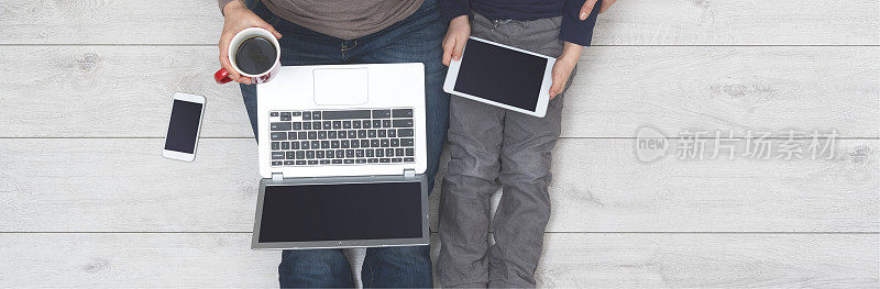 母亲和儿子使用笔记本电脑和平板电脑