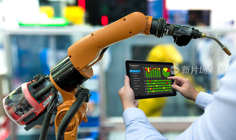 工程师经理手用平板，重型自动化机器人手臂机器在智能工厂工业用平板实时监控生产系统。工业第四物联网概念。