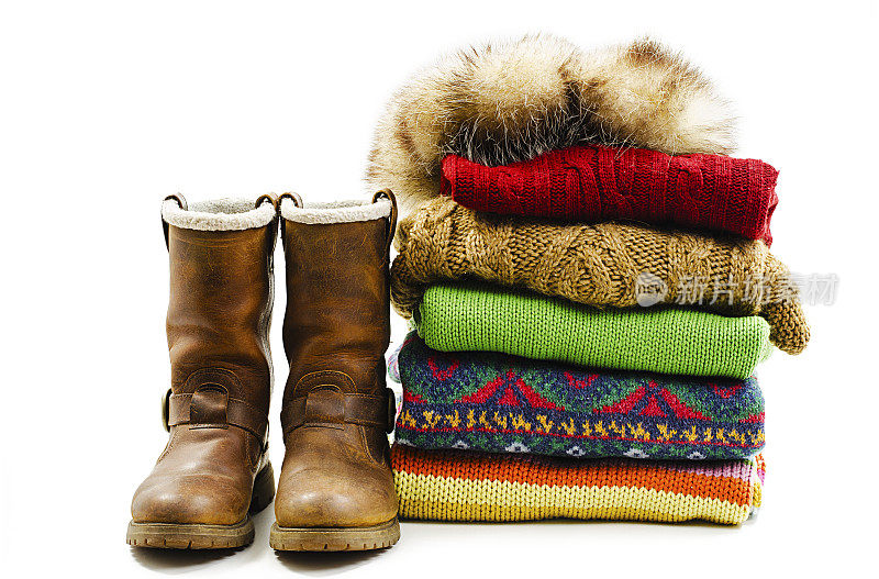 冬天的靴子，帽子和各种毛衣堆叠。冬天的风格