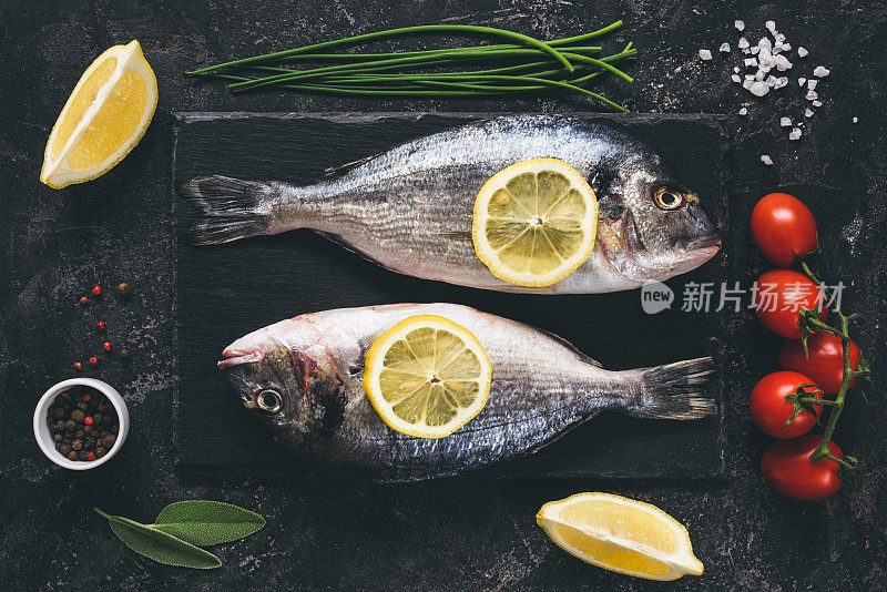 新鲜的鱼与香料，蔬菜和香草石板背景准备烹饪