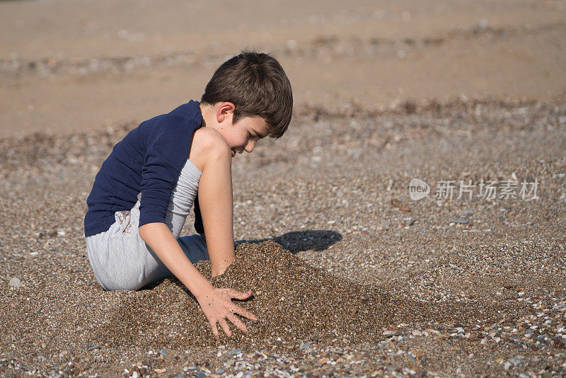 快乐的男孩在一个冬天的一天在沙滩上玩