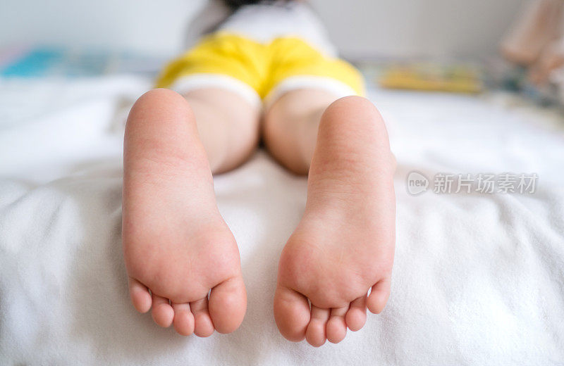孩子们躺在床上看书，大赤着脚