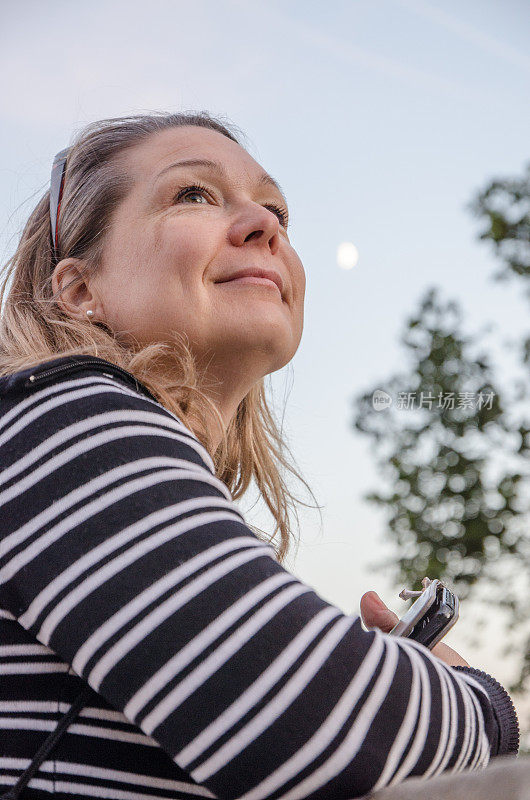 在波兰克拉科夫的夏日夜晚，以月亮为背景的女人的肖像