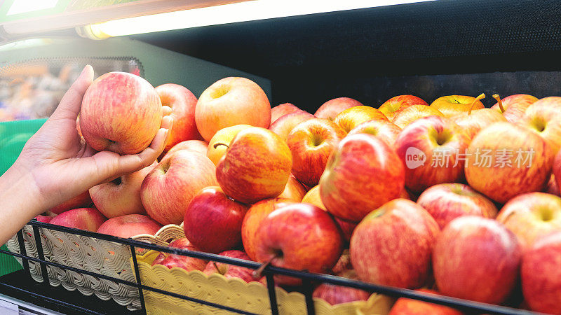 亚洲女性在超市购买苹果水果和健康食品蔬菜