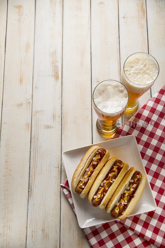白色长凳上的热狗野餐，啤酒和棒球
