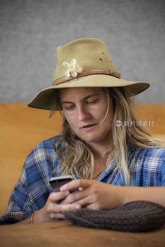 迷人的澳大利亚年轻女子正在查看她的手机。