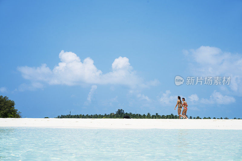 二、年轻美丽的女子在马尔代夫小岛屿海滩的水边奔跑