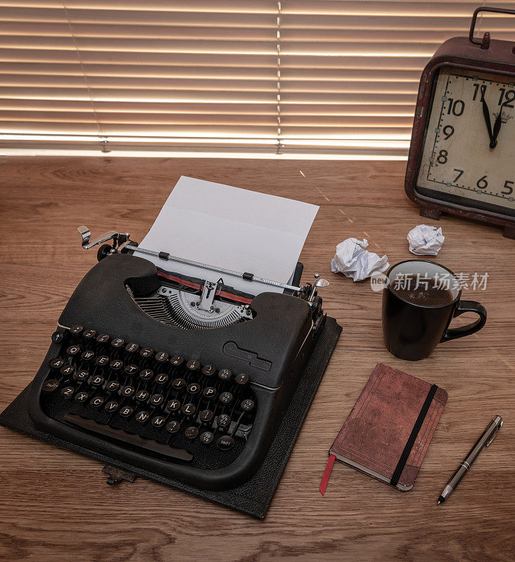 打字机和一堆皱巴巴的纸，还有一台老式打字机