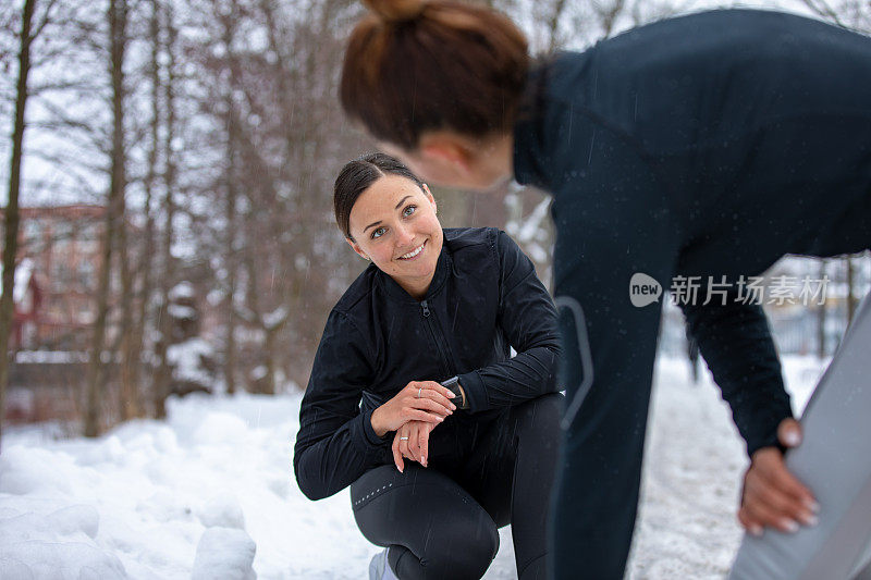 两个穿着运动服的女朋友正在伸展