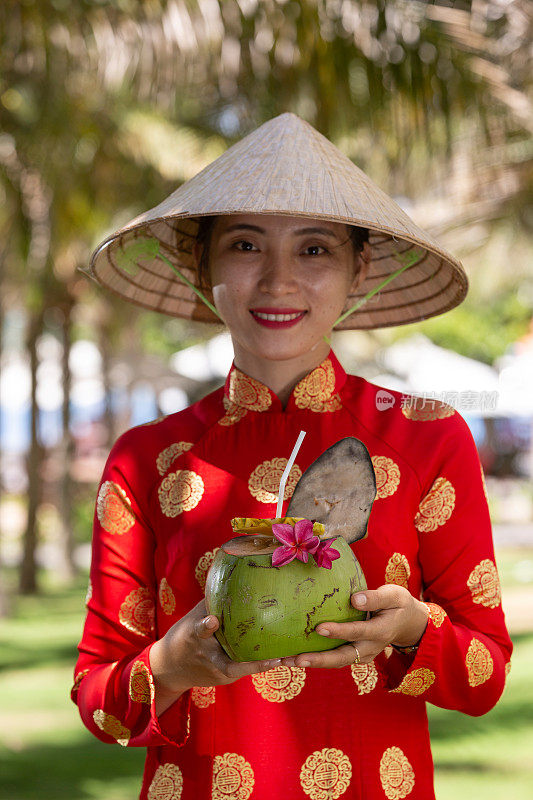 异国情调的传统越南女孩，同时提供新鲜的椰果和鲜花