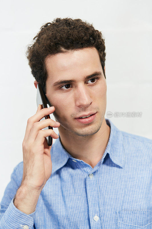 年轻英俊的商人用手机聊天