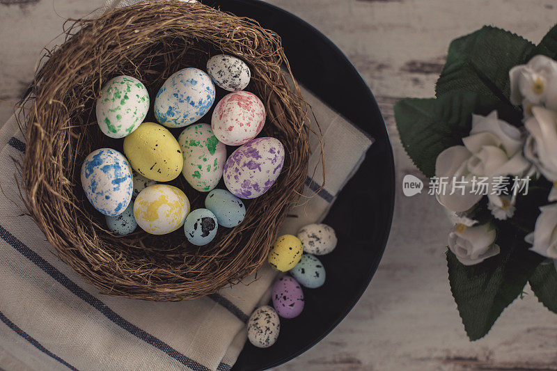 巢里有复活节鹌鹑蛋，桌子上摆放着鲜花