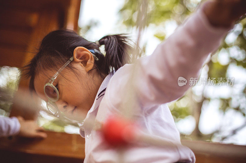 亚洲华人小女孩在操场上爬山