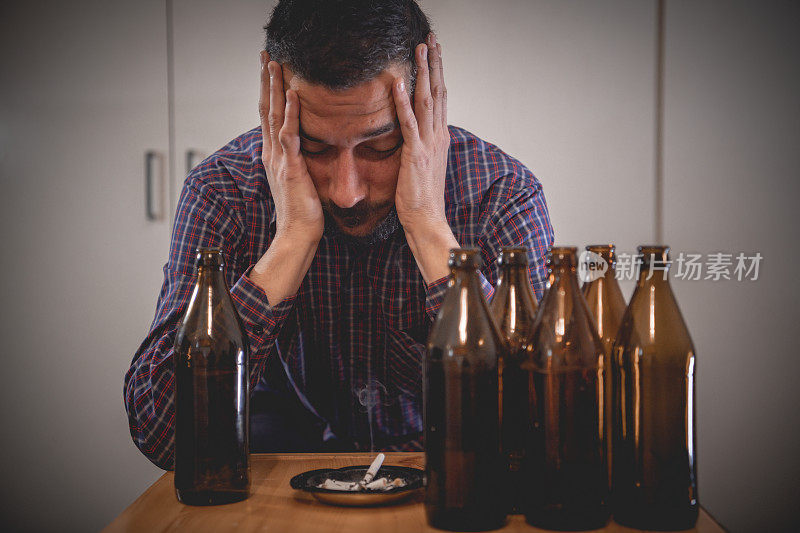 年轻悲伤的醉酒男子喝啤酒和酒精感到浪费，孤独和绝望的痛苦和情绪压力。人与酗酒、上瘾和男人抑郁的概念。